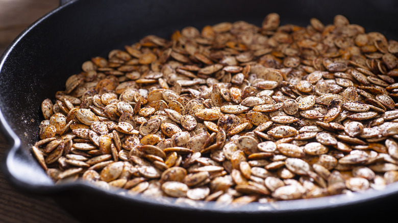 Roasted pumpkin seeds in black cast iron skillet
