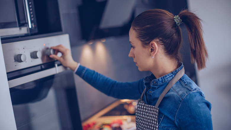 woman turning on the oven