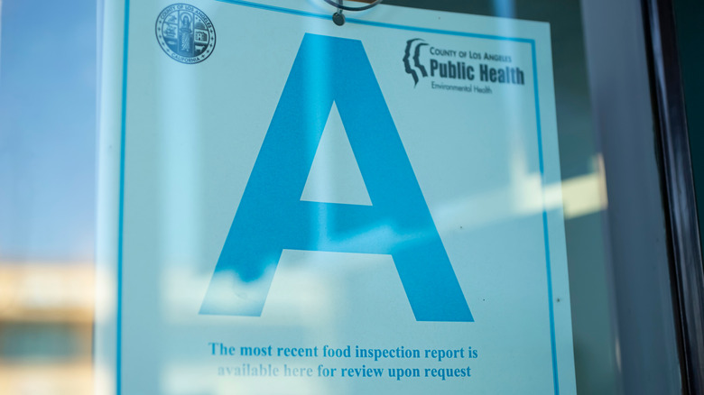 A food inspection window sign with an A-grade score