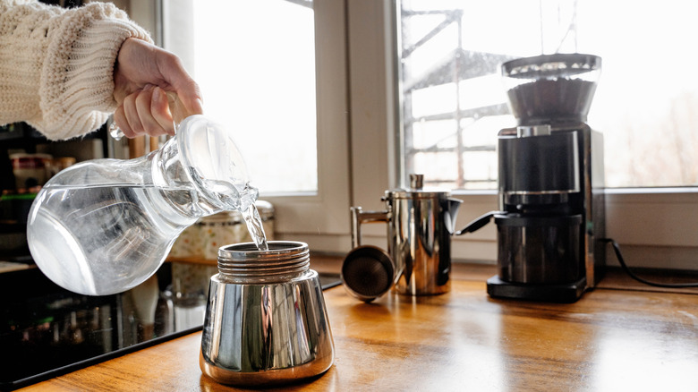 Someone pours water into a water chamber.