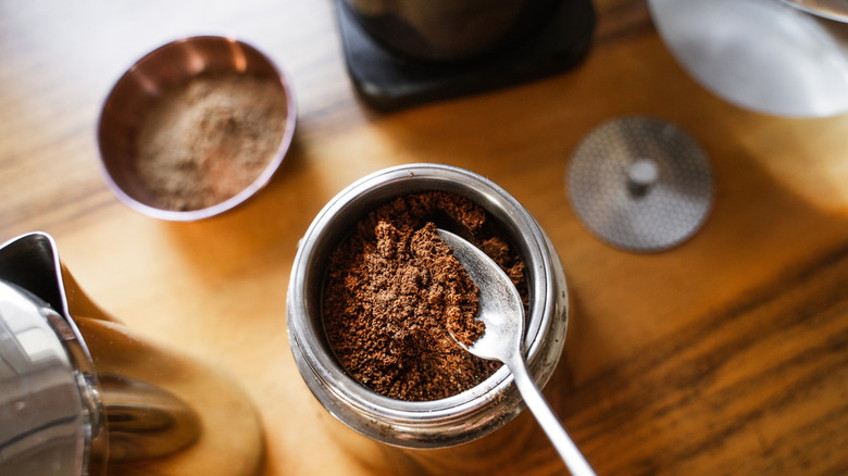 Someone tamps coffee grounds