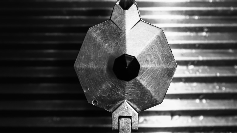 Moka pot surrounded by water droplets.