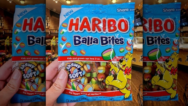 Hand holding a bag of Haribo Balla Bites gummy candies at store