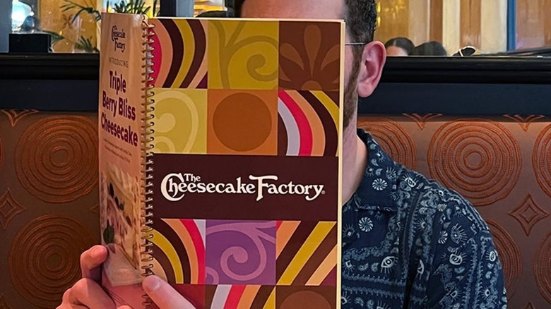 Someone looking at The Cheesecake Factory menu