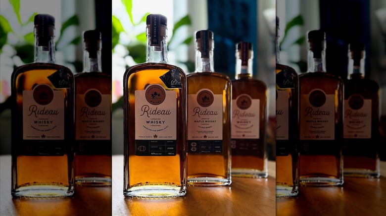 Three bottles of Rideau Whisky on wooden bar.