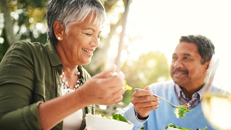 Happy people eating salad