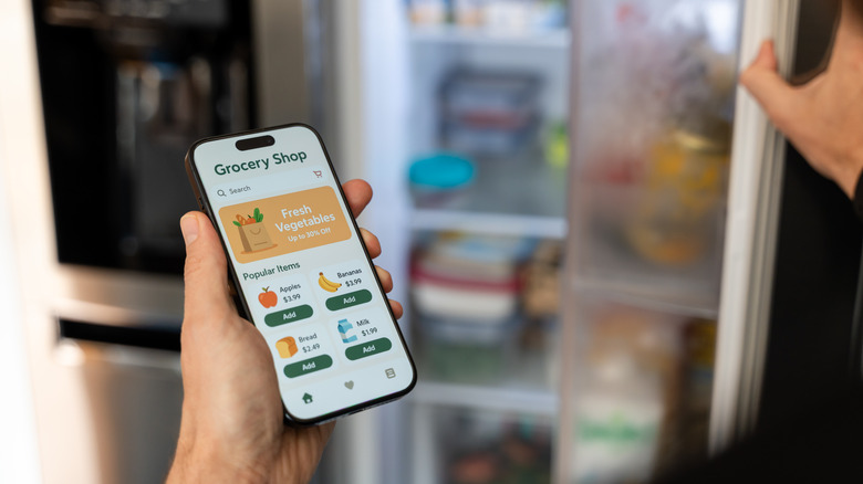 Hand holding a phone with grocery shopping app