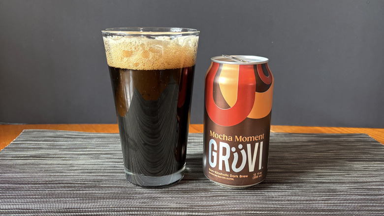Gruvi mocha moment non-alcoholic dark brew in can and glass on dark background