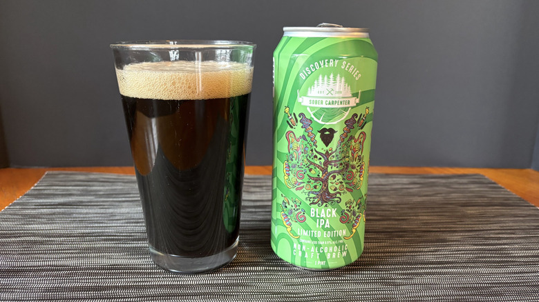 Sober Carpenter's black IPA in can and glass on a dark background