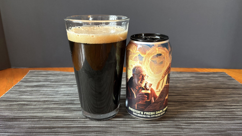 Chester's fresh dark brew non-alcoholic brew by Go Brewing in glass and can on dark background