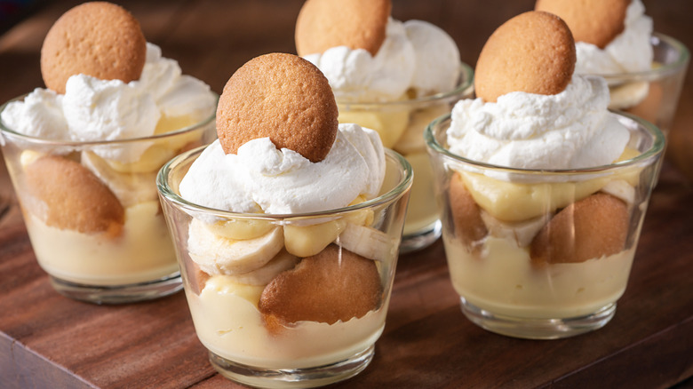 Individual banana pudding cups topped with whipped cream an a vanilla wafer