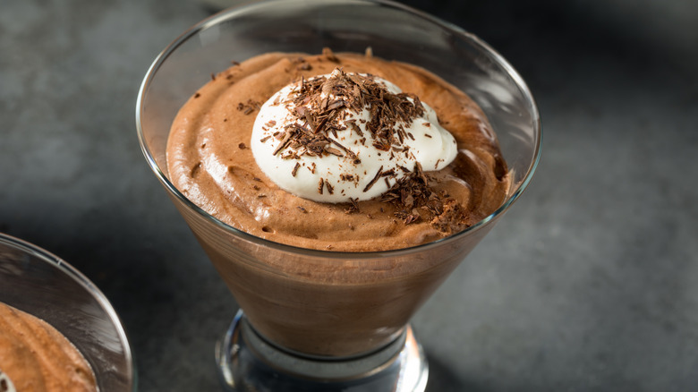 Chocolate mousse in glass dishes with whipped topping and chocolate crumbles