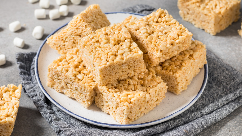 Homemade Rice Krispies treats on a plate with a napkin and mini marshmallows