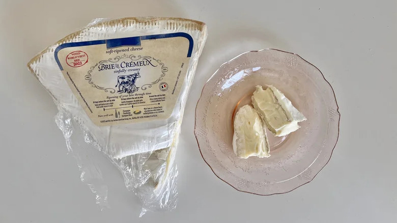 Wedge of Brie Le Crémeux Triple Creme Brie on a table