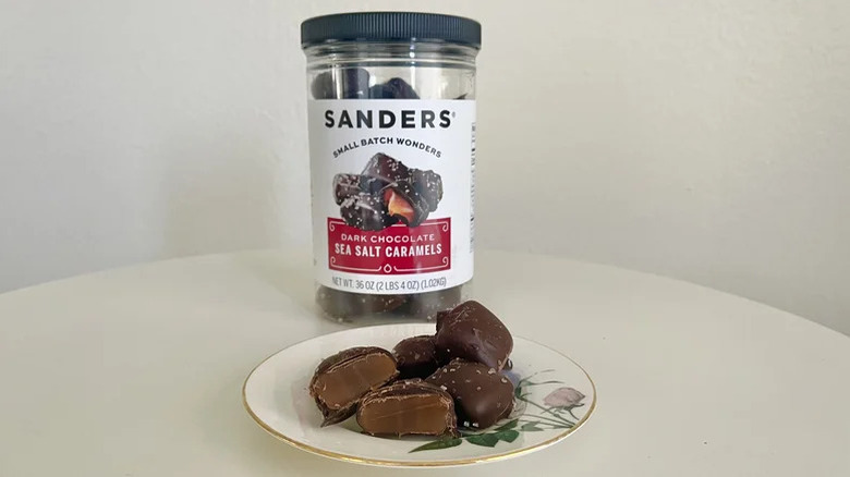 Sanders Dark Chocolate Sea Salt Caramels on a table with a plastic container in the back
