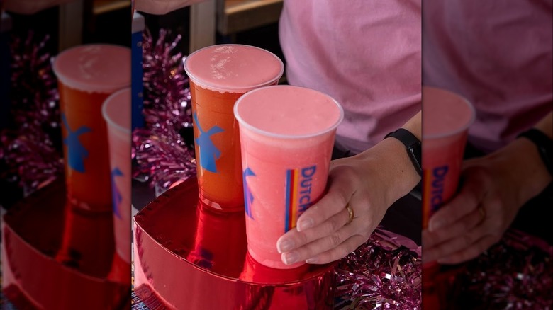 Person holding Dutch Bros Luvstruck Rebel Energy red drinks in iced and frozen form