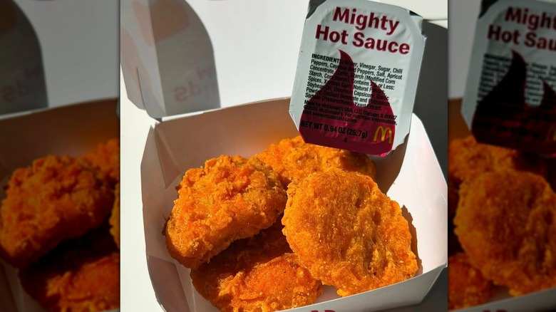 McDonald's Spicy McNuggets with packet of Mighty Hot Sauce inside white cardboard container