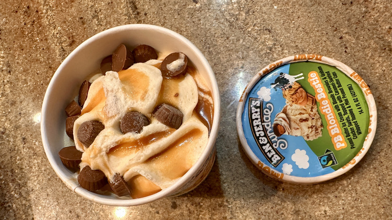 Opened pint of Ben & Jerry's PB Blondie Bestie Sundae with lid next to it