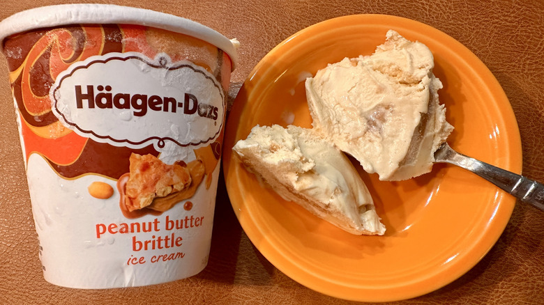 pint of Häagen-Dazs Peanut Butter Brittle ice cream with orange bowl