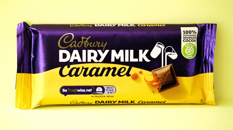 Bar Of Cadbury Dairy Milk Caramel Chocolate against a yellow background