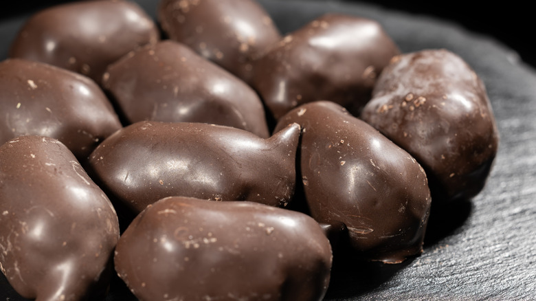 close up of dark chocolate nuts on dark background