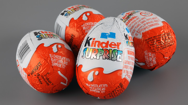 four kinder surprise eggs on dark grey background