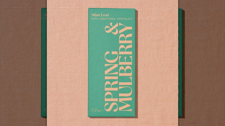 Mirrored image of Spring & Mulberry Mint Leaf chocolate bar on light pink background
