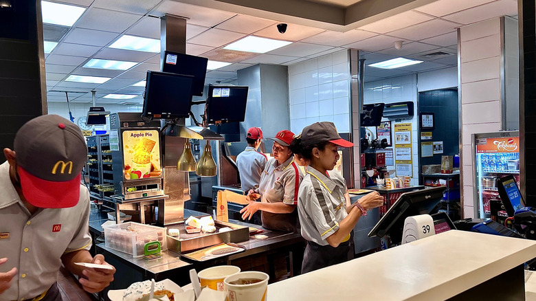 McDonald's employees behind the counter in the restaurant kitchen