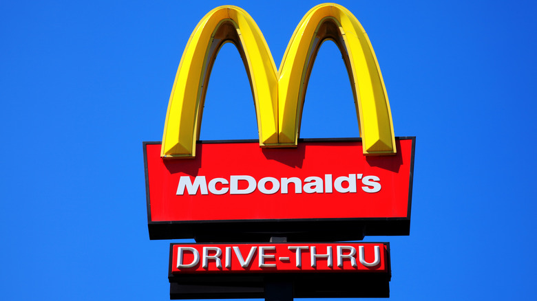 McDonald's drive-thru sign against blue sign