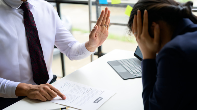 man rejecting resume of candidate during job interview
