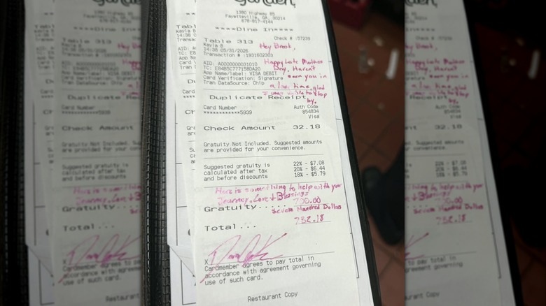 an Olive Garden check with a handwritten note and $700 tip, mirroed image