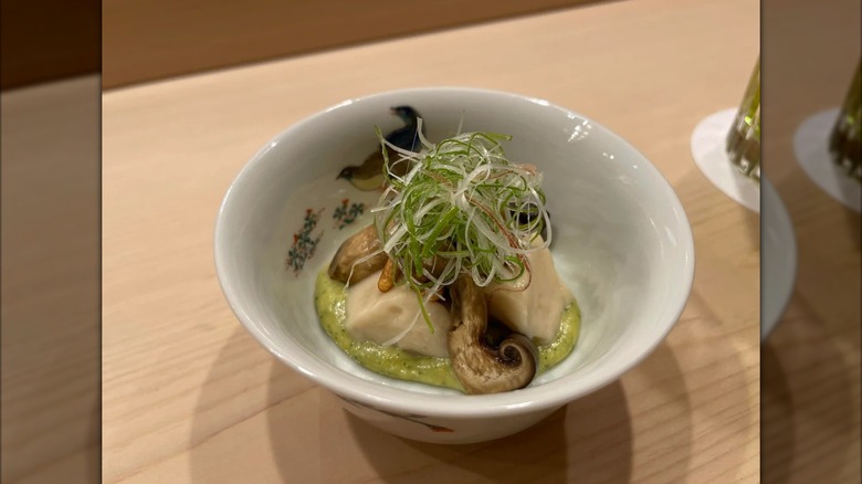 Mirrored image of tofu and mushroom dish in white bowl on table