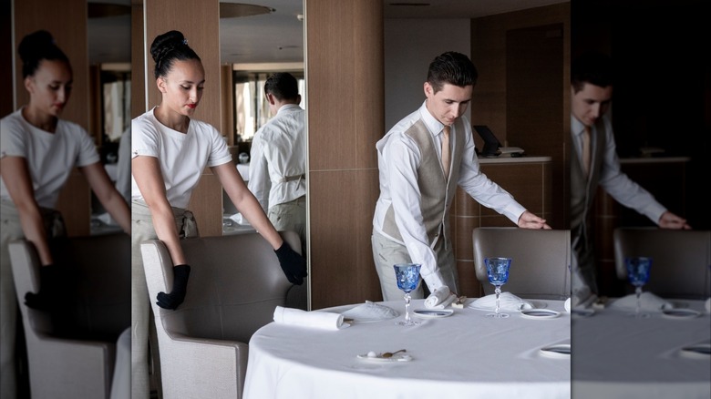 Mirrored image of servers preparing a table at La Vague d'Or