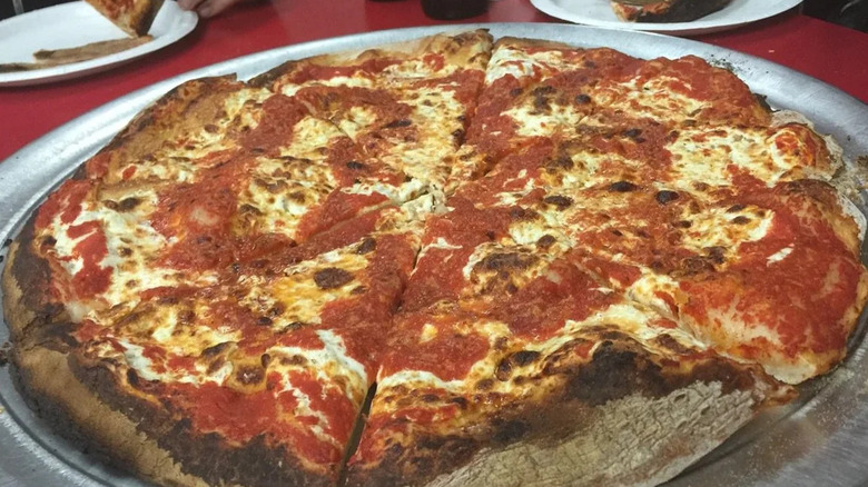 Close up of large margarita pizza on silver plate