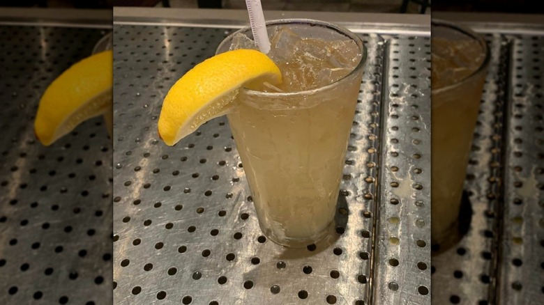Texas Roadhouse Top Shelf LIT with lemon garnish on metal bartop, with mirror borders