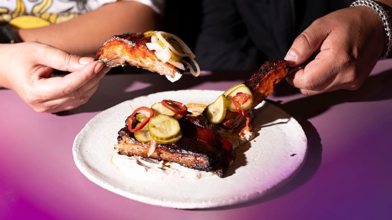 people sharing plate of lamb ribs at Boia De