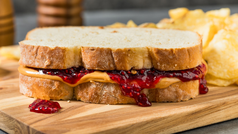 Peanut butter jelly sandwich on wooden cutting board