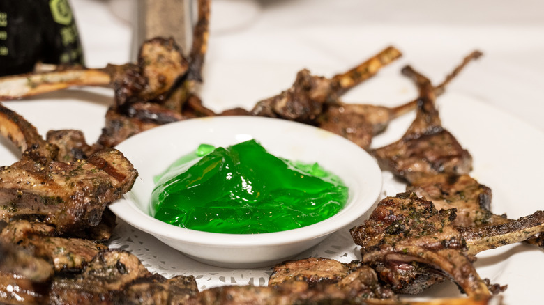 A platter of lamb chops with mint jelly in the center