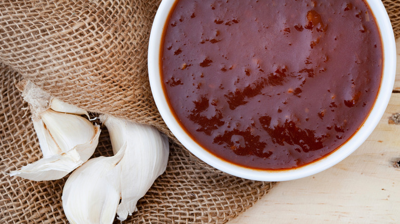 Monkey sauce in a dipping bowl alongside some garlic cloves