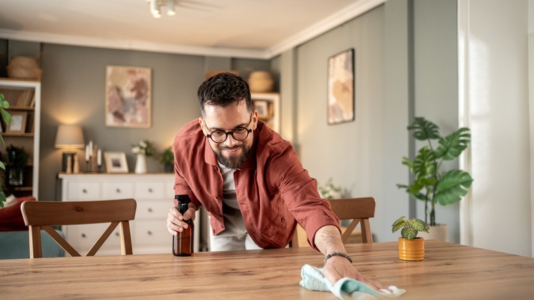 Man cleaning table with spray