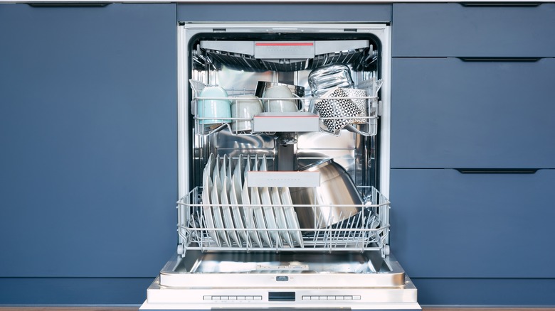 Front view of dishwasher, filled with crockery and cookware