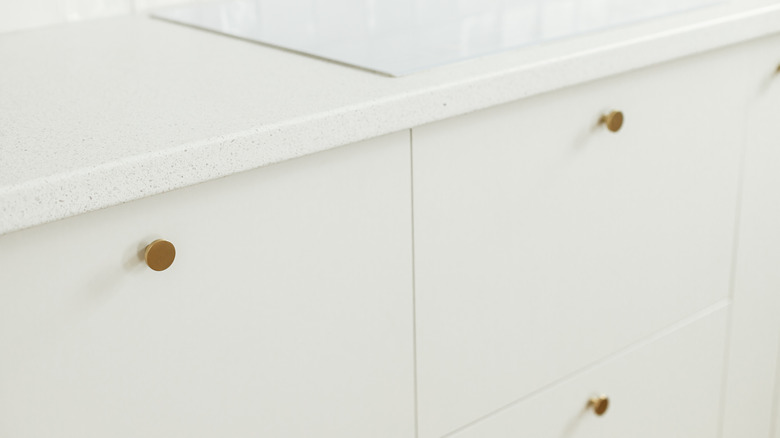 Stylish white kitchen cabinets with brass knobs
