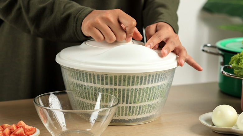 Person using salad spinner in the kitchen