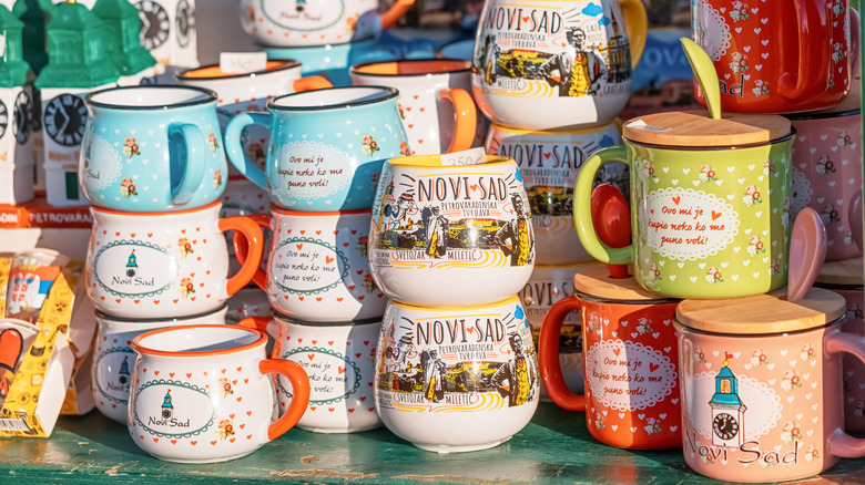 Several souvenir mugs stacked at a tourist stall