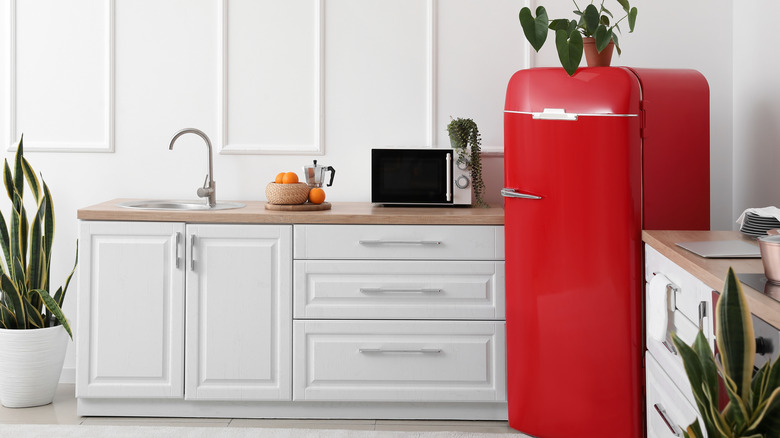 Light modern kitchen with white cabinets and retro red refrigerator
