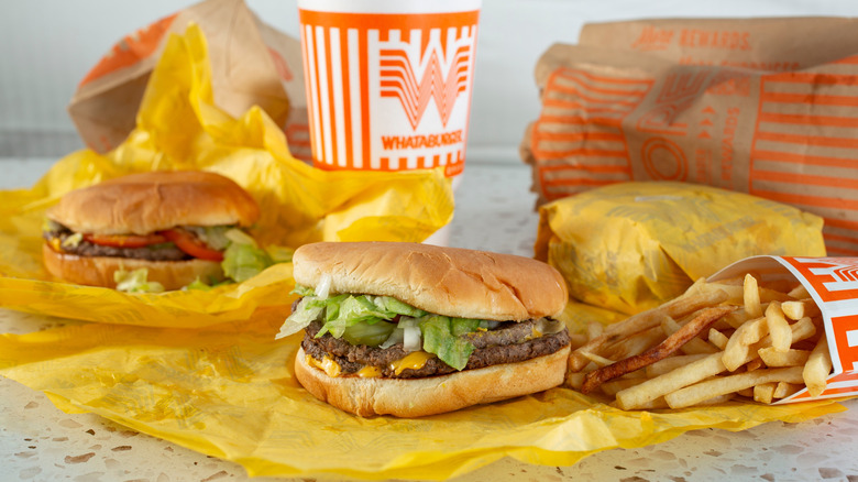 Whataburger unwrapped burgers, a drink, and fries on a table