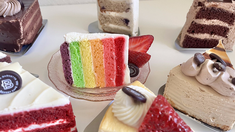 Rainbow cake and other cakes on table