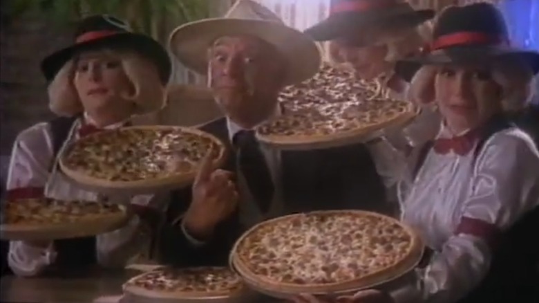 Still from Godfather's Pizza commercial with people holding pizzas