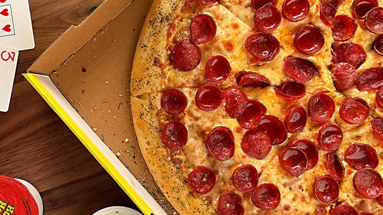 A Hungry Howie's pepperoni pizza in a box next to dipping sauces