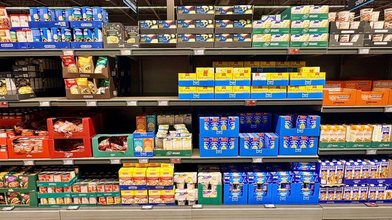 Shelves at Aldi filled with products like macaroni cheese, broth, and canned goods